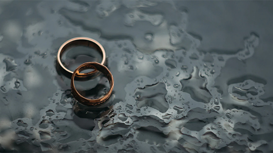two gold rings sitting on the ground surrounded by rain; image used for blog post about tax issues for divorced couples