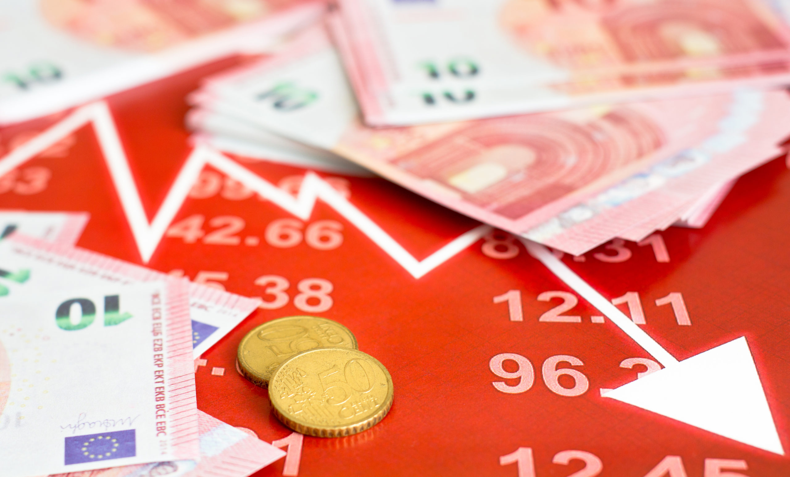 Concept of european stock market trading. Chart with currencies prices. euro coins on the graph. Several twenty euros bills near the coins. Ball pen and calculator on the diagram.