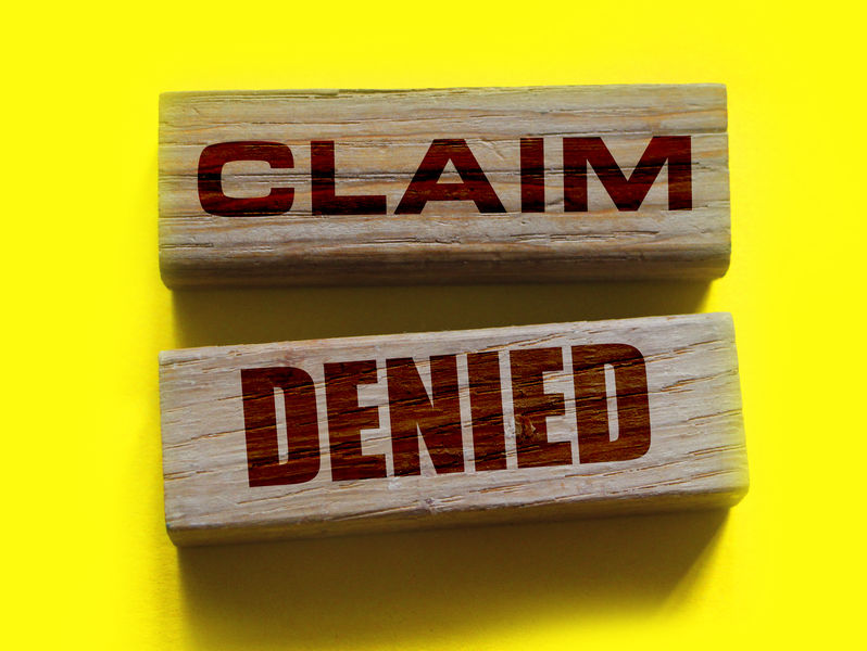 Wooden Blocks with the text: Claim Denied. Insurance Business concept