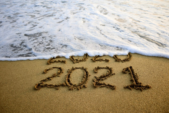 New year 2021 and 2020 on sandy beach with waves