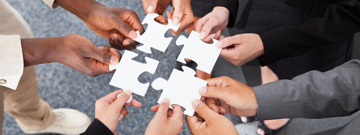 Close-up Photo Of Businesspeople Holding Jigsaw Puzzle