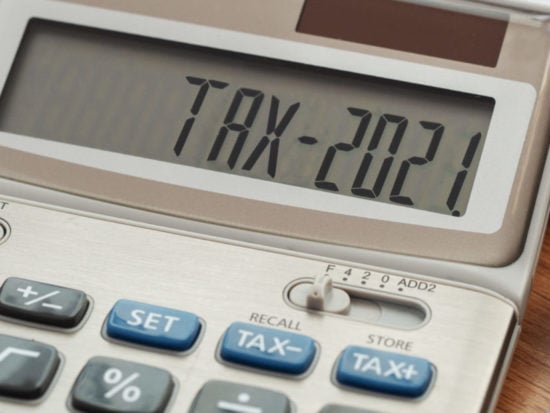 Tax word and 2021 number on calculator. Business and tax concept. Pay tax in 2021 years.