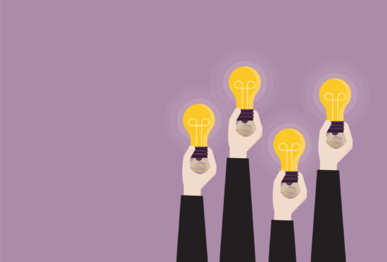 Businessperson holding a light bulb together