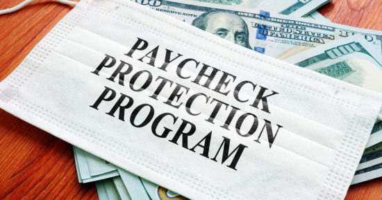 PPP Paycheck Protection Program as SBA loan written on the mask and money.