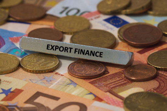 export finance - the word was printed on a metal bar. the metal bar was placed on several banknotes