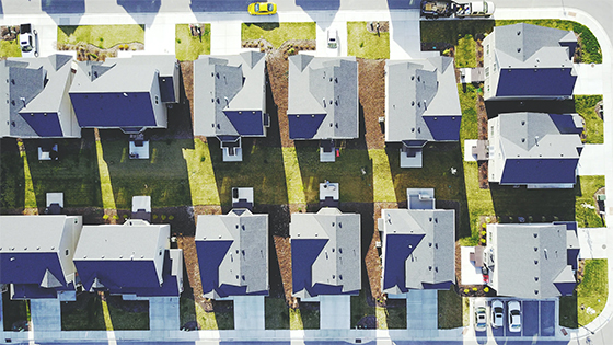 an overhead view of a neighborhood with houses; image used for blog post about determining house basis before buying or selling