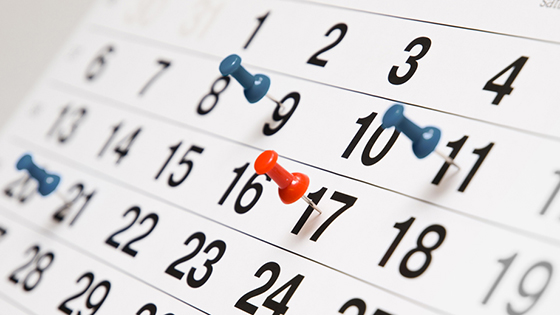 calendar with blue and red push pins; image used for blog post about importance of tax return filing and payment deadlines