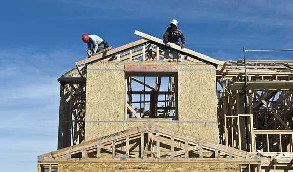 Single home under construction with 2 builders on the roof