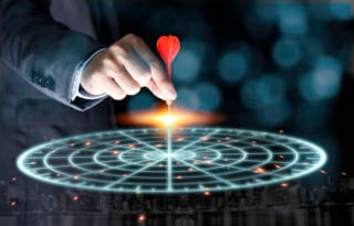 Businessman throwing red arrow dart to virtual target dart board. Setup objectives and target for business investment concept.