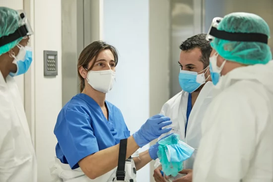 Female Doctor Talking with Medical Team in Protective Wear