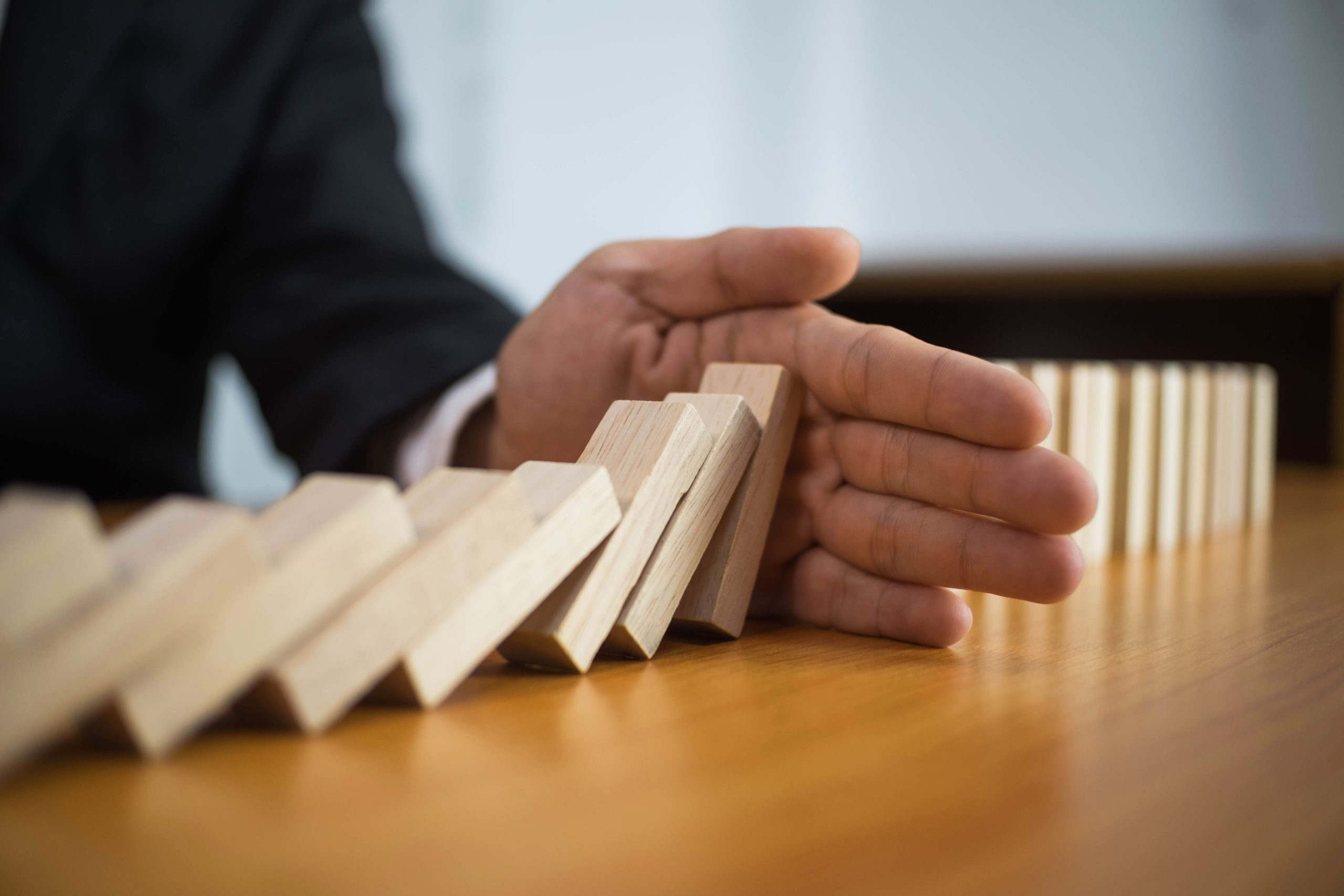 Businessman,Hand,Stops,Domino,Continuous,Overturned,Meaning,That,Hindered,Business