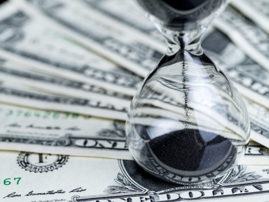Wage hour Hourglass on US dollars - shutterstock_793576108