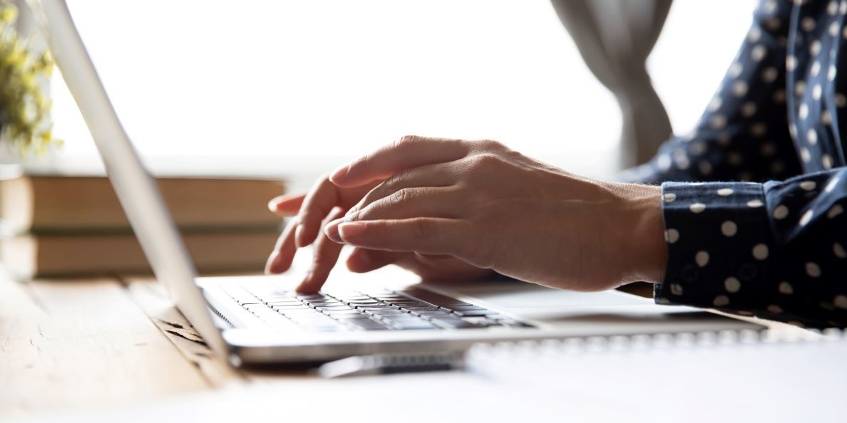Woman's hands working on laptop - web- iStock-1198252560