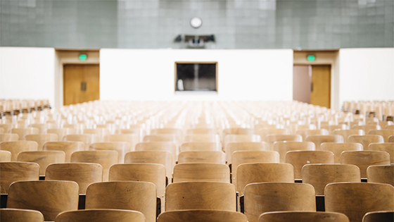 empty wooden chairs in a classroom; image used for blog post about scholarships are tax free but result in taxable income