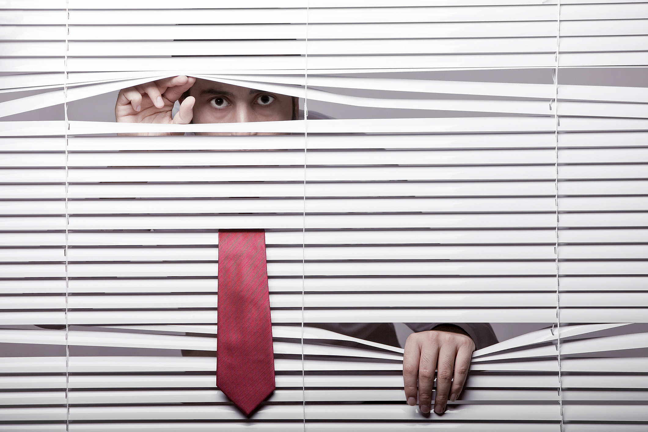 Man Watching through window blinds