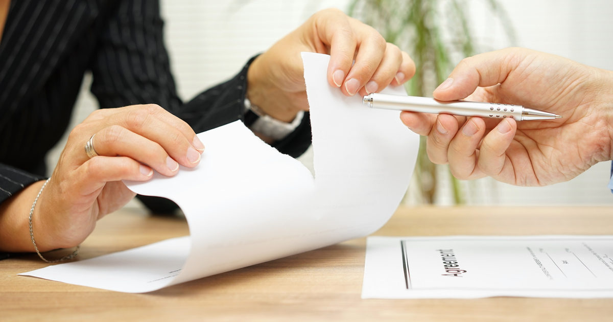 Woman tears agreement documents in front of agent