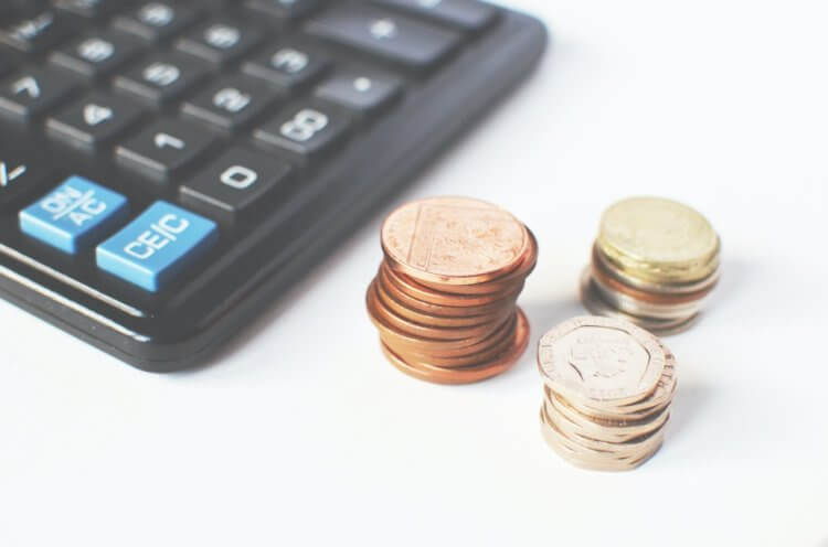 pexels-breakingpic-3305 stacks of coins next to a calculator