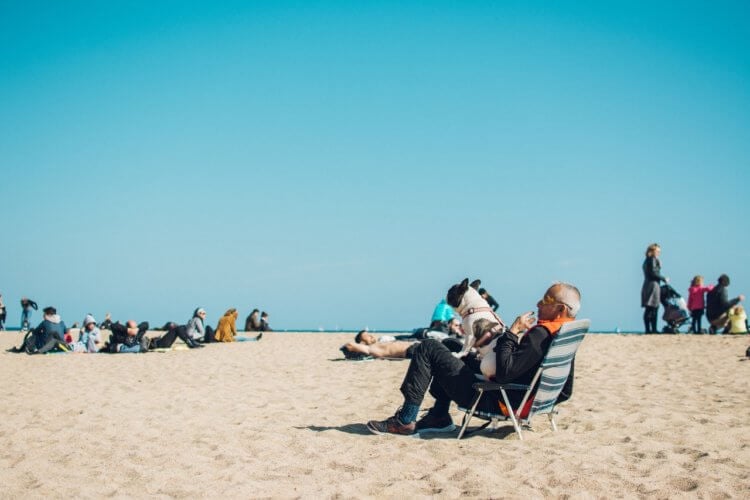 pexels-huy-phan-1377070 older man on a beach with a french bulldog
