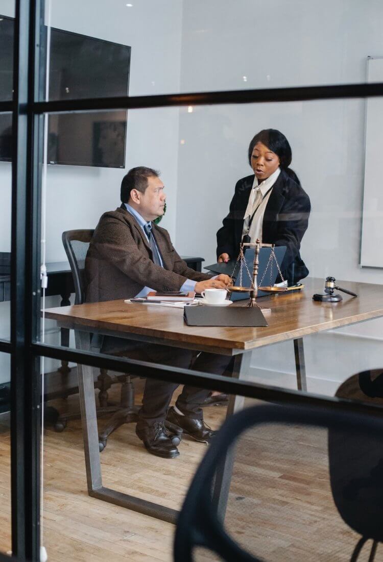 Two legal professionals going over a mistake made in a billing spreadsheet Two legal professionals going over a mistake made in a billing spreadsheet