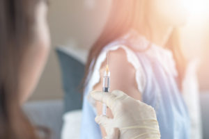 a person getting a COVID shot as part of federal vaccine mandates