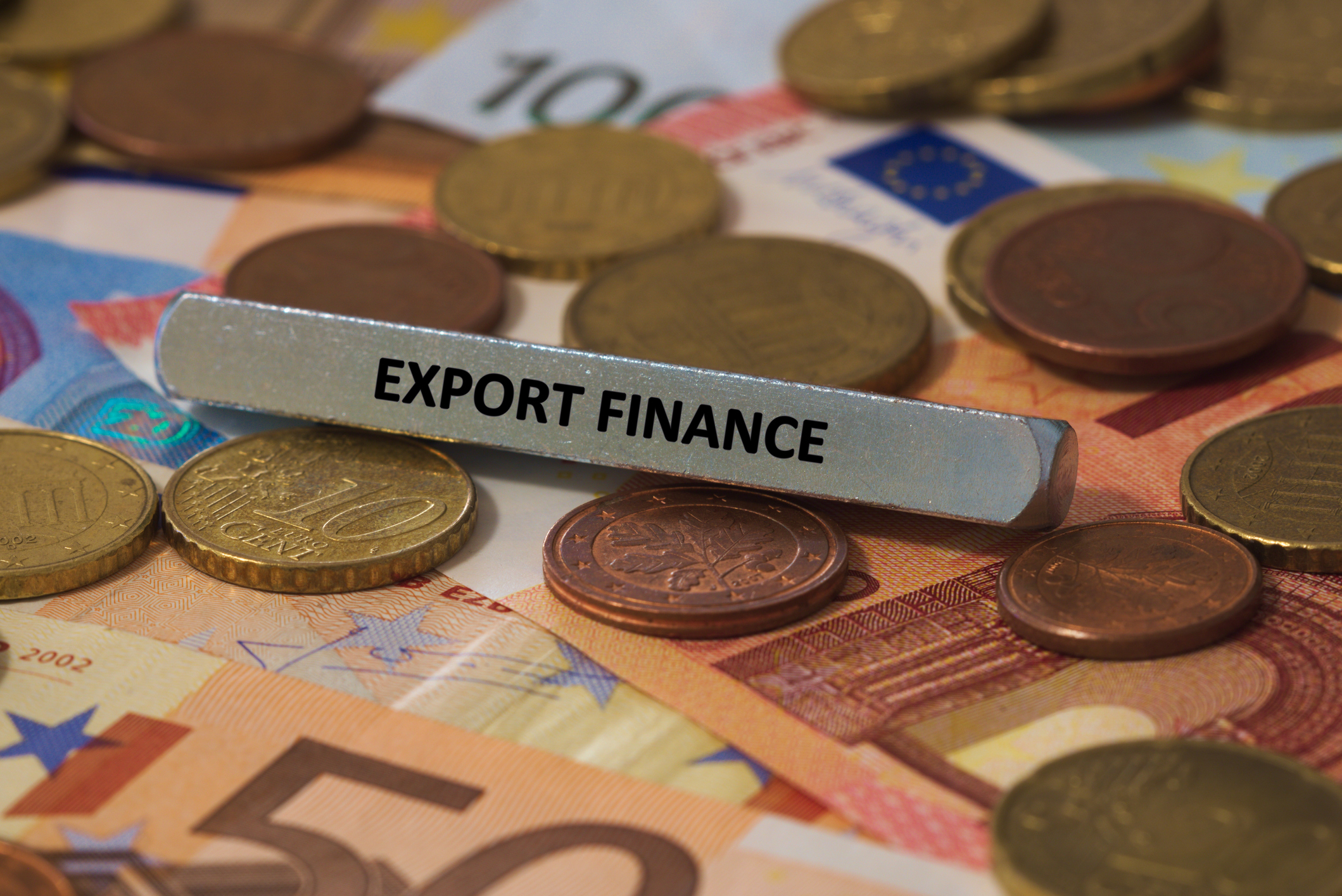 export finance - the word was printed on a metal bar. the metal bar was placed on several banknotes