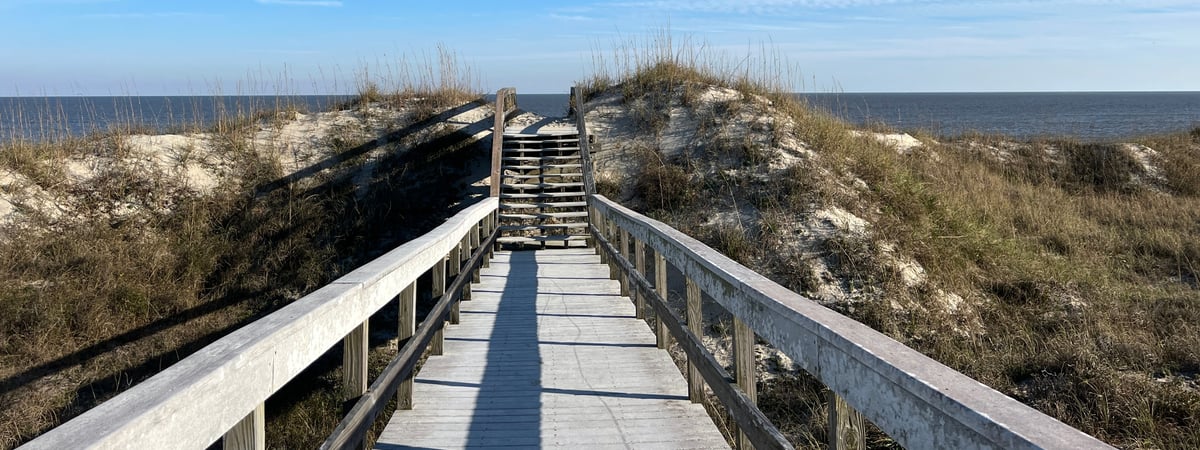 A sand covered boardwalk over the dunes to the Atlantic ocean on Jekyll Island, Georgia