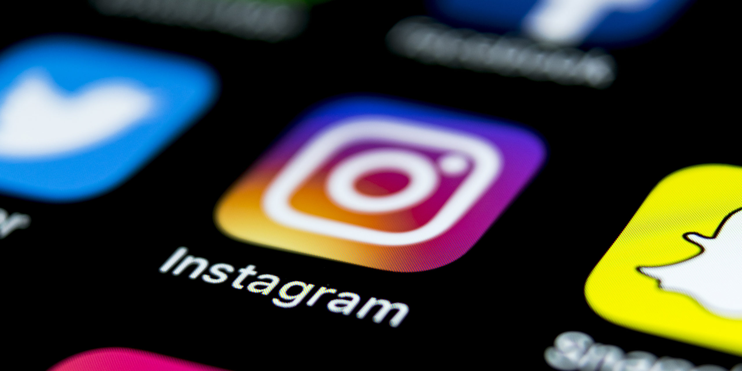 Apple iPhone X on office desk with icons of social media network instagram application on screen. Social network. Starting social media app.