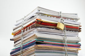 stack of papers with lock representing filings under seal