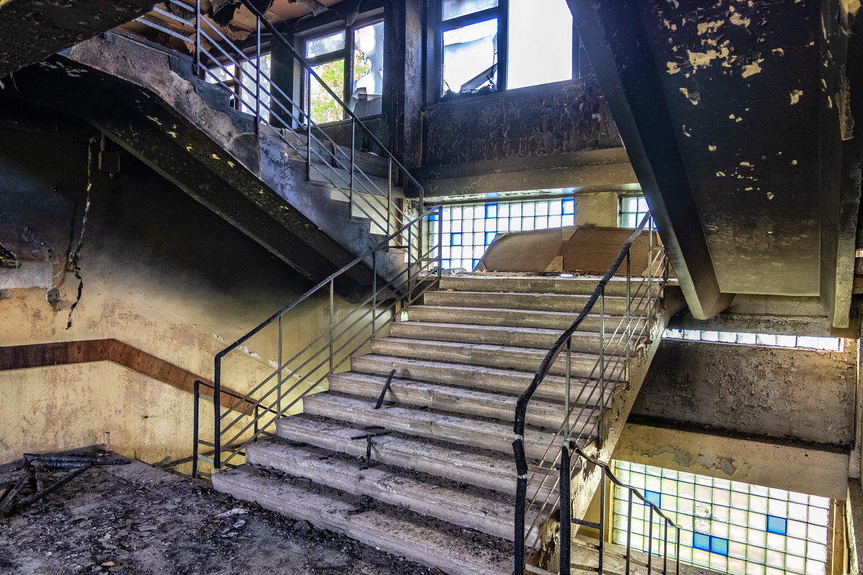 Burned interiors after fire. Walls and staircase in black soot