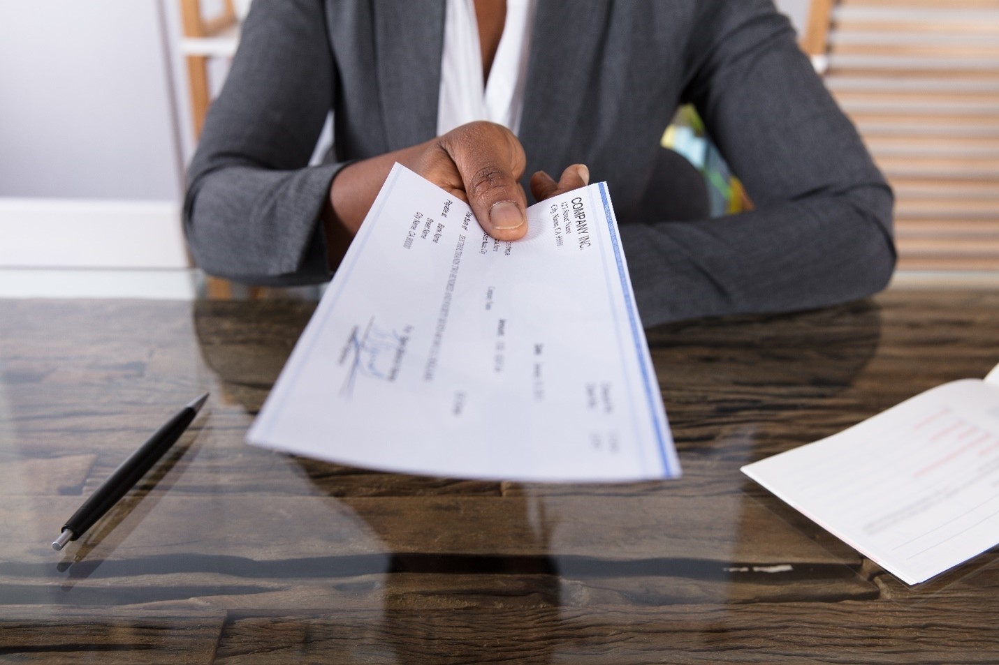 Handing_PayCheck_Over_Desk