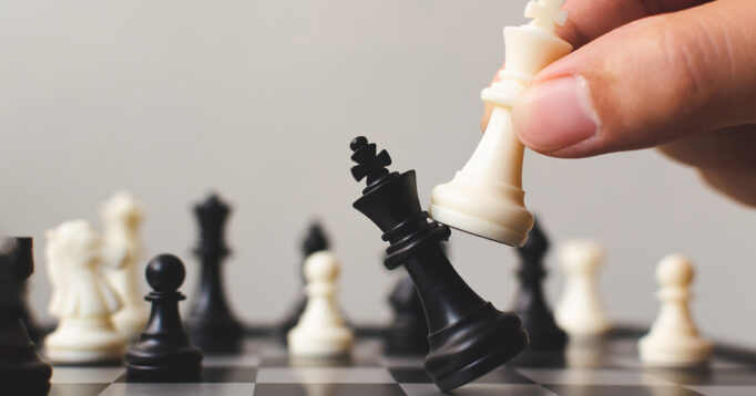 Plan leading strategy of successful business competition leader concept, Hand of player chess board game putting white pawn.