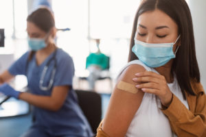 woman who has a bandaid on after receiving vaccination representing religious accommodation guidance for employers