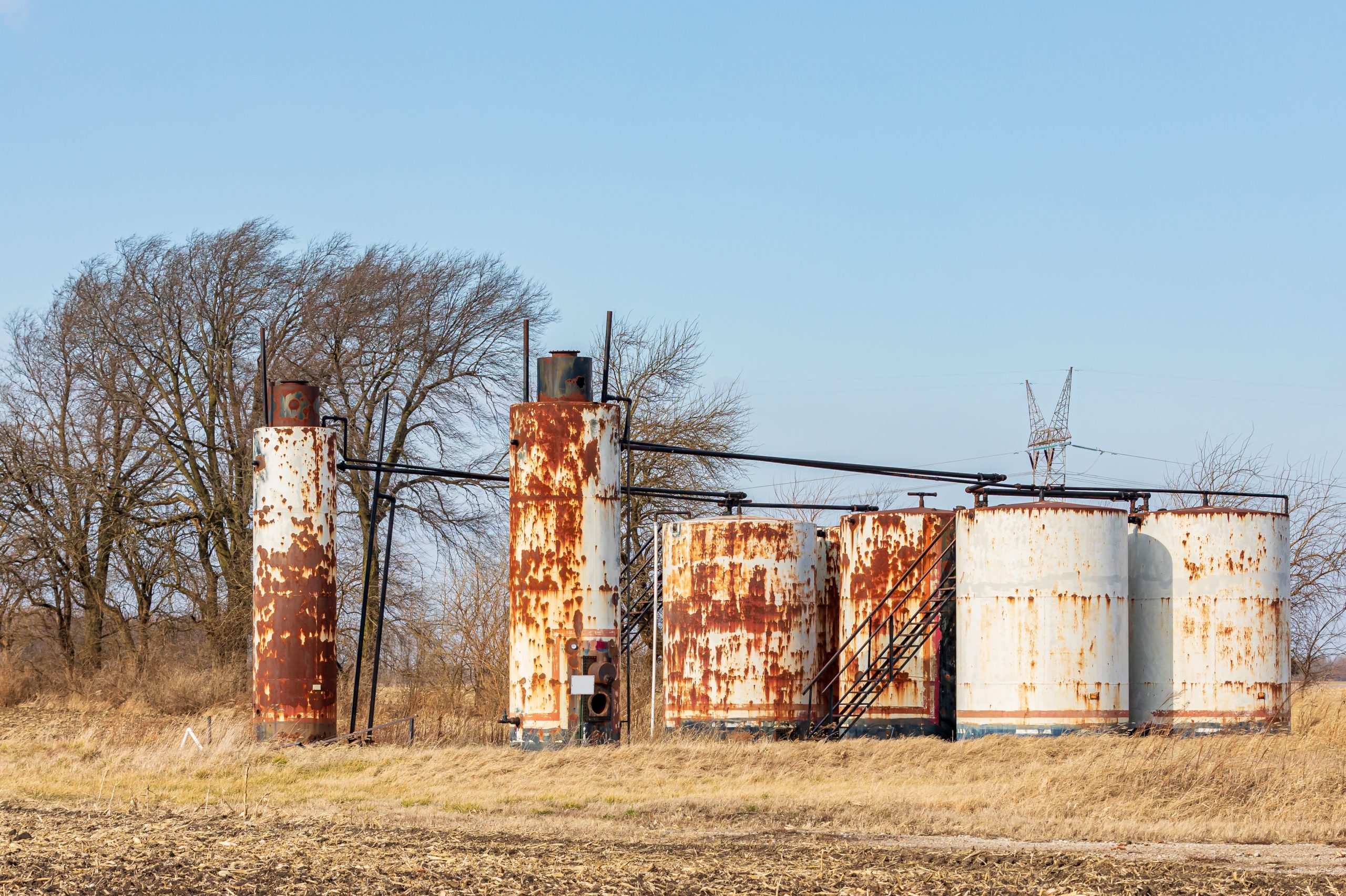 Old,Oil,Well,Storage,Tanks,In,Farm,Field.,Oil,Well