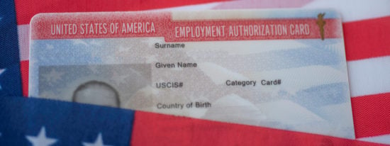 Employment Authorization card on USA Flag surface. Close up view. Wide photo