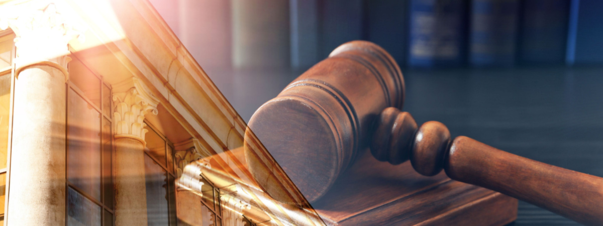 Law protection. Double exposure of wooden gavel and court building-Shutterstock_1768849280