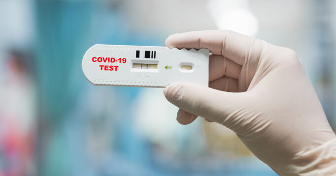 Doctor hand holding positive Coronavirus or Covid-19 rapid test