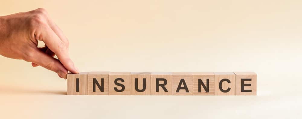 Need for Insurance in Joint Ventures Commercial and Business Law hand puts wooden cube with letter i from word insurance word is written wooden cubes standing yellow surface table can be used business education concept min - Need for Insurance in Joint Ventures in Commercial and Business Law