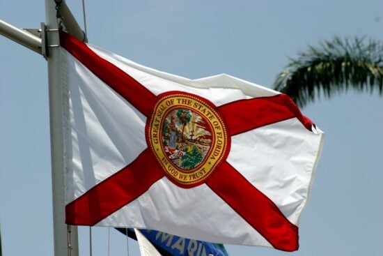 The state flag of Florida flies on a ship's mast.
