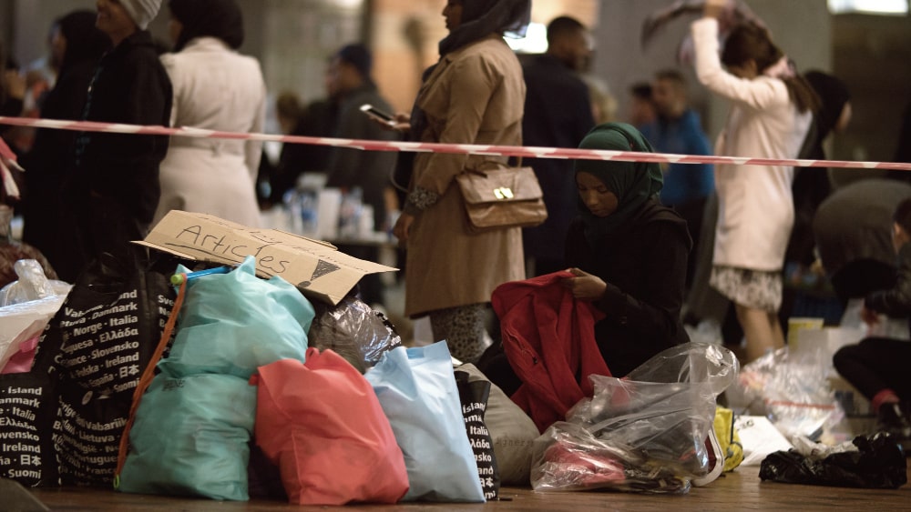 aid worker distributing clothes charity collecting point copenhagen railroad station min - Refugee Deportation in the EU in General
