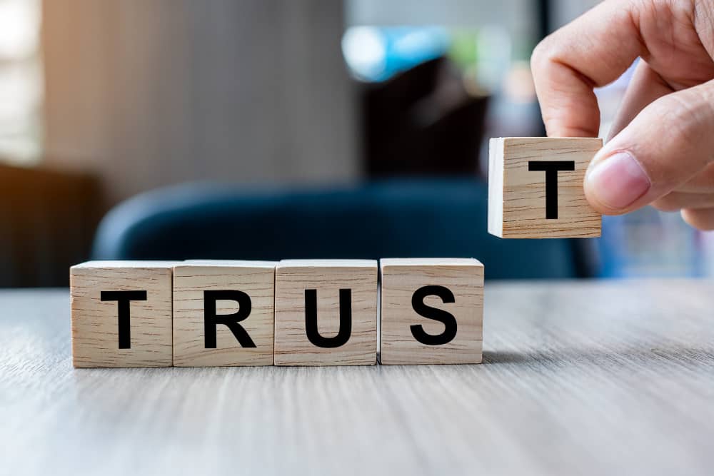 Antitrust Law General businessman hand holding wooden cube block with trust business word table background min - Antitrust Law in General