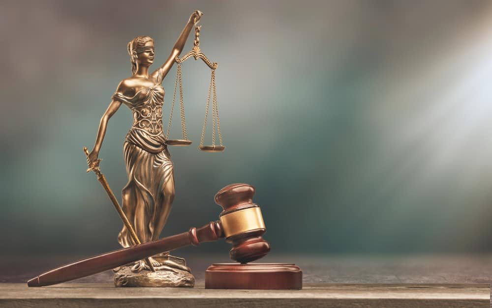 Sue Someone Commercial and Business Law justice scales books wooden gavel table justice concept min - Sue Someone in Commercial and Business Law