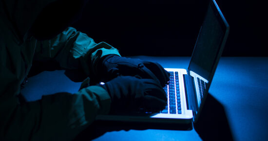 Payments System Hacking. Online Credit Cards Payment Security Concept. Hacker in Black Gloves Hacking the System.