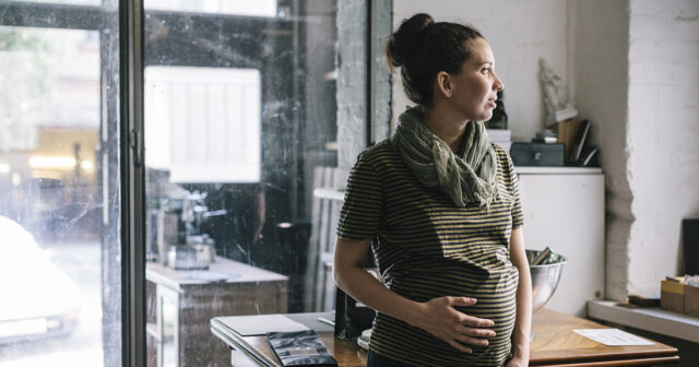 Pregnant woman talking a break while working in Roastery