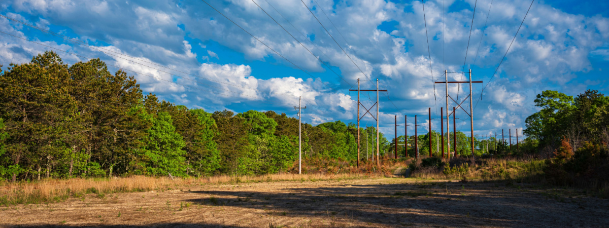 Cloudscapes and long shadows over the open field footpath under electric power lines-Shutterstock_1747763090