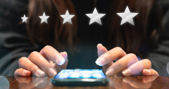 Hands of young woman completing customer satisfaction survey on electronic mobile smartphone with five silver graphic stars