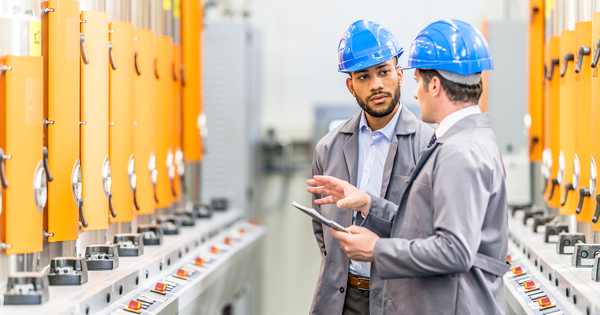 Engineers talking while inspecting machinery
