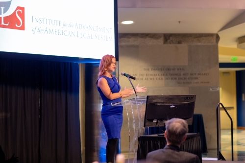 "woman in blue dress behind podium on stage"