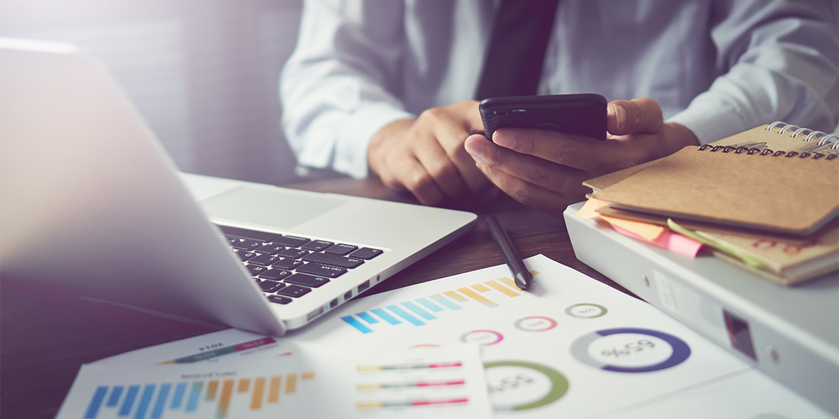 businessman hand working smart phone on wooden desk in office in morning light. The concept of modern work with advanced technology. vintage effect