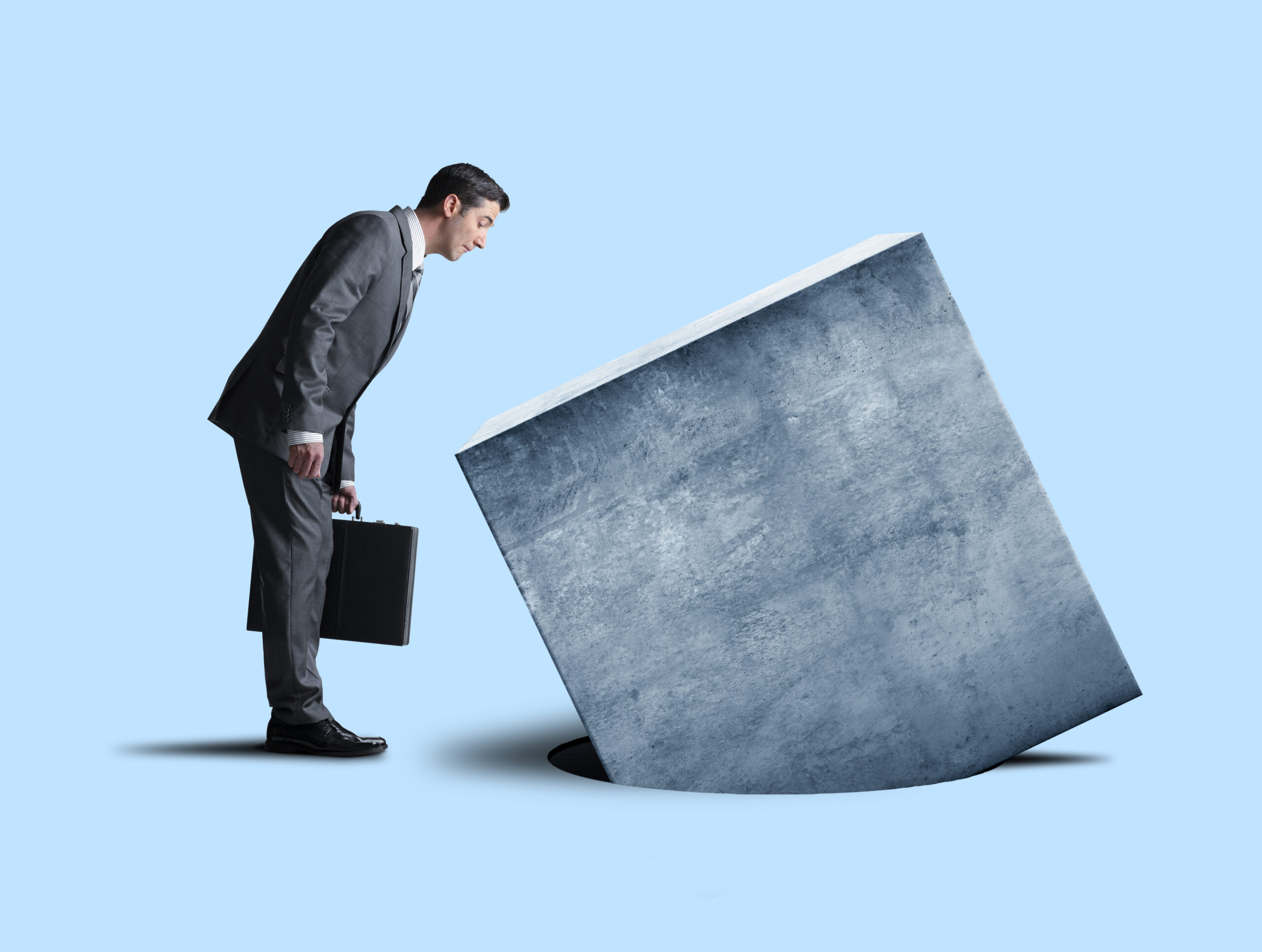 Businessman Looking At Square Peg not Fitting Into Round Hole
