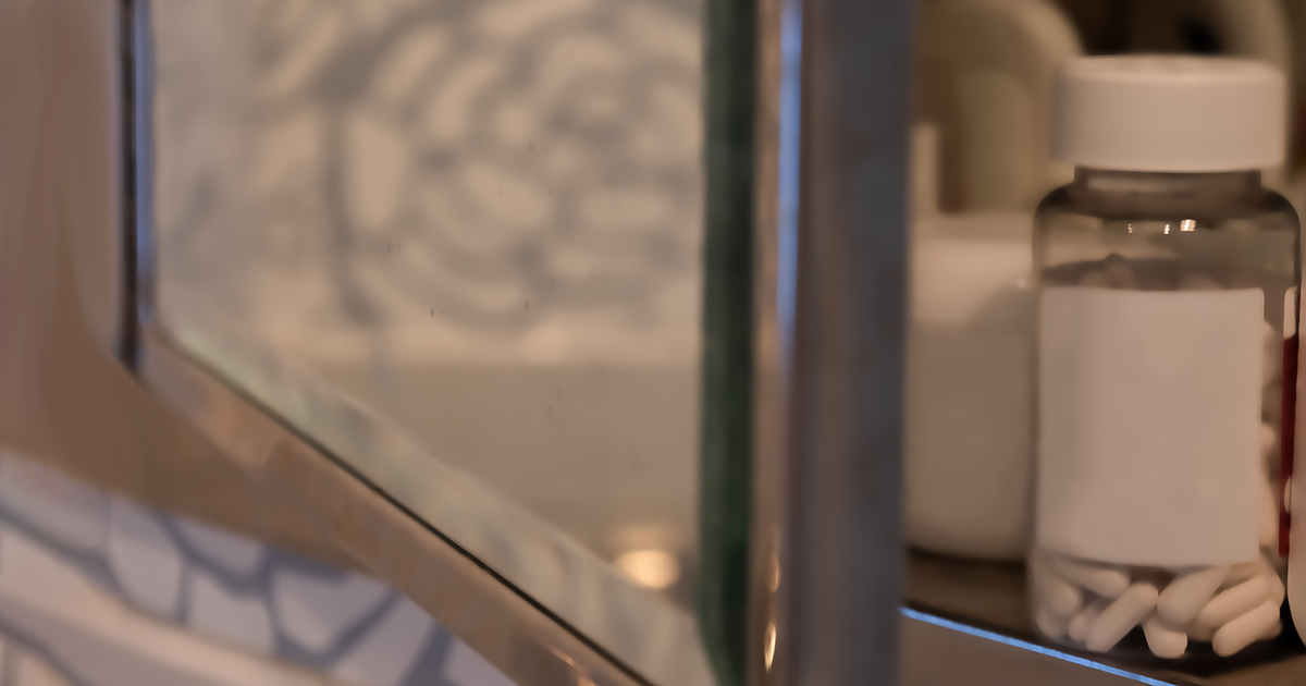 inset glass medicine cabinet in bathroom with door slightly ajar